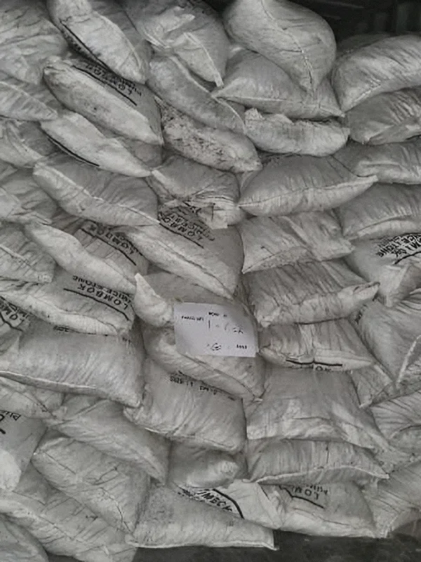 Container more than half full of pumice bags